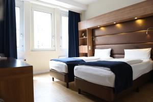 a hotel room with two beds and a window at Motel Plus Berlin in Berlin