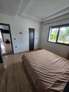 a bedroom with a large bed and a window at Appartement RDJ in Dar Hamida +4 photos