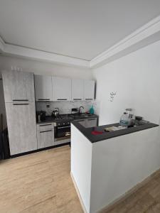 a kitchen with white cabinets and a counter top at Appartement RDJ in Dar Hamida