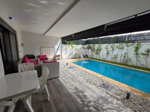 a living room with a pool and a table and chairs at Appartement RDJ in Dar Hamida