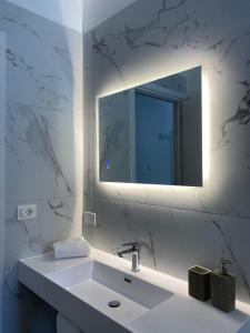 a white bathroom with a sink and a mirror at Residenza Vittoria in Petacciato