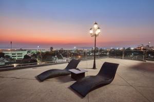 twee stoelen en een tafel op een dak met een straatlicht bij Tribe Pattaya SHA certificated in Jomtien Beach