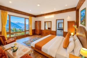 a bedroom with a bed and a large window at The Ganga lodge, Manali - Affordable Luxury Stay Near Mall Road Manali in Manāli