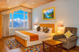 a bedroom with a bed and a chair and a window at The Ganga lodge, Manali - Affordable Luxury Stay Near Mall Road Manali in Manāli