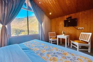 a bedroom with a bed and a tv and a window at The Ganga lodge, Manali - Affordable Luxury Stay Near Mall Road Manali in Manāli