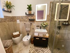 a bathroom with a toilet and a sink and a shower at Gioia B&B in Cirò Marina +7 photos