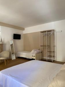 a bedroom with two beds and a tv on the wall at Residenza Vittoria in Petacciato