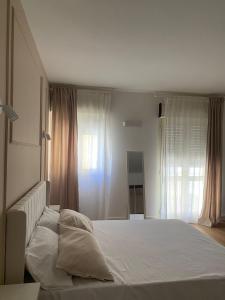 a bedroom with a white bed and a window at Residenza Vittoria in Petacciato