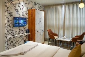 a hotel room with a bed and a tv on a wall at Hotel Krushnai Deluxe in Nandre +26 photos