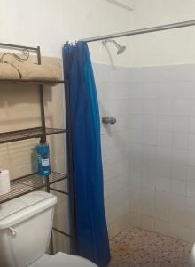 a bathroom with a shower with a blue shower curtain at Yayi Maria in Río Hato