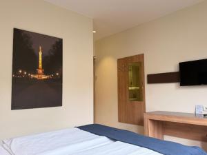 a bedroom with a bed with a picture of the eiffel tower at Motel Plus Berlin in Berlin