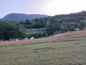 a grassy field with a river and a mountain at slavko in Šipovo