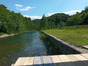 a river with a wooden bridge in a field at slavko in Šipovo