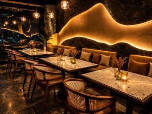 a row of tables in a restaurant with lights at Hotel ZP Grand in Bhilai