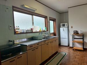 a kitchen with a sink and a refrigerator at ゲストハウス美和館 in Imabari +24 photos