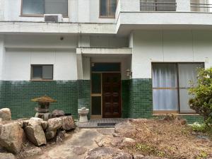 a house with a green and white at ゲストハウス美和館 in Imabari