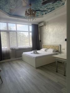 a bedroom with a bed and a ceiling at Rodnik in Almaty