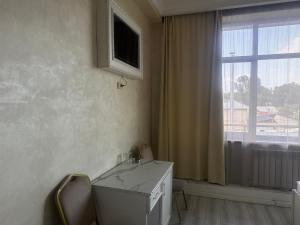 a white desk in a room with a window at Rodnik in Almaty
