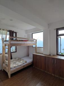 a bedroom with a bunk bed and two windows at Mochilero Homestead in Pelling