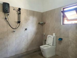 a bathroom with a toilet and a shower and a window at Dee Holidays in Moratuwa +23 photos