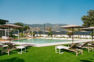 a swimming pool with lounge chairs and umbrellas at Heaven Room in Striano