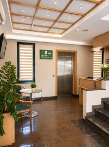 eine Bürolobby mit einem Tisch und einer Treppe in der Unterkunft Hotel Orijent 22 in Laktaši