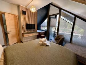 a bedroom with a large bed and a tv at Uzungol Ada Bungalow in Uzungöl +54 photos