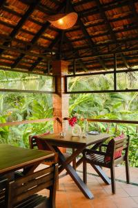 ein Holztisch und Stühle auf einer Terrasse in der Unterkunft ETHER Marari Beachfront in Mararikulam