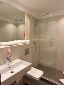 a bathroom with a sink and a shower at Motel Plus Berlin in Berlin +40 photos