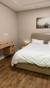 a bedroom with a bed and a wooden floor at شقة غرفة وصالة مريحة in Jeddah