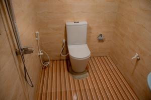a bathroom with a toilet on a striped floor at Little Pumpkin Cabanas & seafood restaurant in Tangalle +101 photos