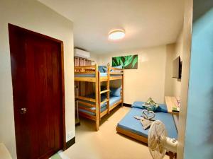 a room with two bunk beds and a fan at Mongki's Pension House in Puerto Princesa City +32 photos