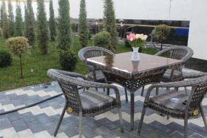 a table and chairs with a vase of flowers on a patio at Art Moderno Hotel in Tashkent