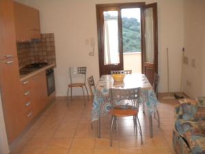 a kitchen and dining room with a table and chairs at Le case in collina - San Teodoro in Lu Lioni