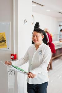 a man in a white lab coat holding a refrigerator at Hotel Mediterrane in Sarandë +216 photos