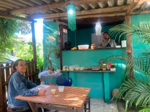a woman sitting at a table in a restaurant at Pousada Suíte Conexao in Conceição da Barra