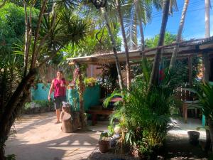 a woman walking a dog in front of a house at Pousada Suíte Conexao in Conceição da Barra