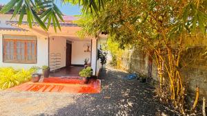 a house with a porch and a courtyard with plants at Spl inn in Trincomalee +17 photos