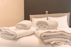 a pile of towels sitting on top of a bed at Baja Suites in Kalamata +129 photos
