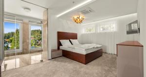 a bedroom with a bed and a large window at Apartmány Star Lipno - Self Check-in in Lipno nad Vltavou