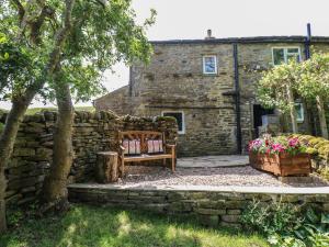 a stone house with a bench in front of it at Wain Wath Cottage in Richmond