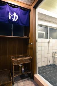 a bathroom with a shower with a flag on the wall at Guest House Bokuyado in Kyoto +39 photos