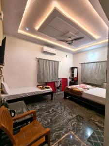 a living room with two beds and a tv at Hampi Lake House in New Hampi