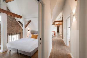 a bedroom with a white bed and a brick wall at Hotel Oderberger in Berlin +73 photos