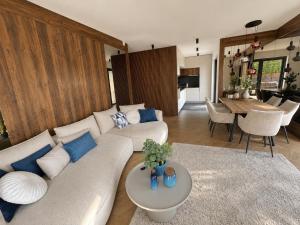 a living room with a couch and a table at Villa Porta Verde IV - Infinity pool BBQ Luxury in Balatonalmádi