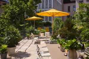 a patio with tables and chairs with umbrellas at Widder Hotel - Zurichs Luxury Hideaway in Zurich