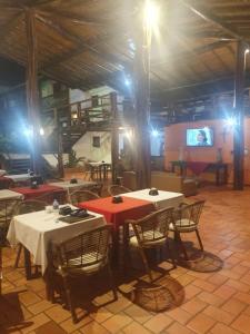 a dining room with tables and chairs and a tv at Fantasia do Agreste in Jandaíra
