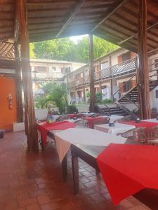 a group of tables in a building with red tables at Fantasia do Agreste in Jandaíra