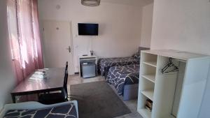 a small room with a bed and a desk and a table at Ferienwohnung Berlin - Schönefeld Flughafen mit Küche in Schönefeld