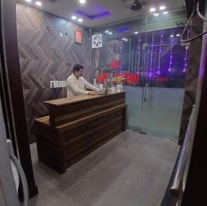 a man standing at a counter in a restaurant at Hotel Taj in Pānīpat